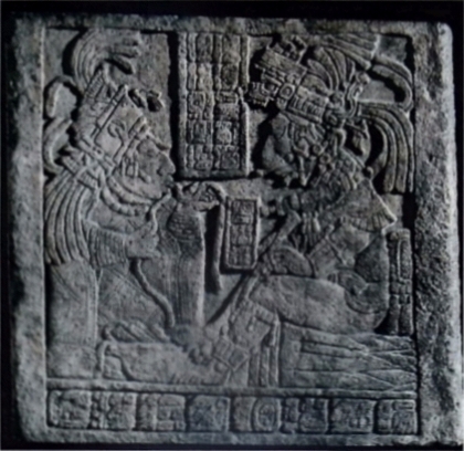 Incisione maya su pietra da Yaxchilán, Messico (VIII sec. d.C.). Le figure mostrano il dio Uccello-Giaguaro, che indossa un'acconciatura di serpente con la testa di teschio, mentre esegue l'atto del salasso rituale assieme a una delle sue mogli. I gliﬁ al centro della stele trascrivono un testo che descrive la scena. © British Museum, Lintel 17 1886320, London