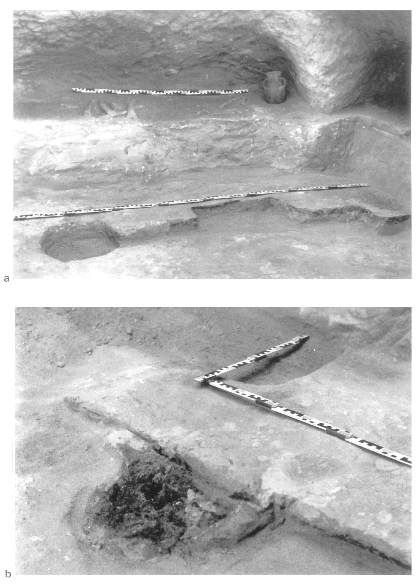 Fig. 4 Cagliari, Tomba IV di via Basilicata, largamente danneggiata dall'escavatrice meccanica, alla profondità di m 3, nelle fondazioni della Scuola di San Vincenzo. Si nota (con riferimento al rilevamento di Tav. 4): in a, lo scheletro adagiato sul bancone ovest in posizione contratta e con fiasca (v. Tav. 5, 20) presso il capo; in a e b il battuto pavimentale di argilla rossa con focolare a cappella piena di carbonella, preziosa testimonianza di tradizionali antichi rituali funerari. (foto E. Atzeni).